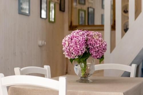 a vase of purple flowers sitting on a table at Emma's House in Sasseta