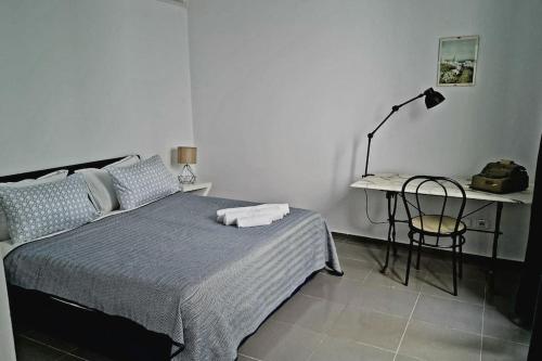 a bedroom with a bed and a desk with a lamp at La Maisonnette Turquoise in Dar Mimoun Bey