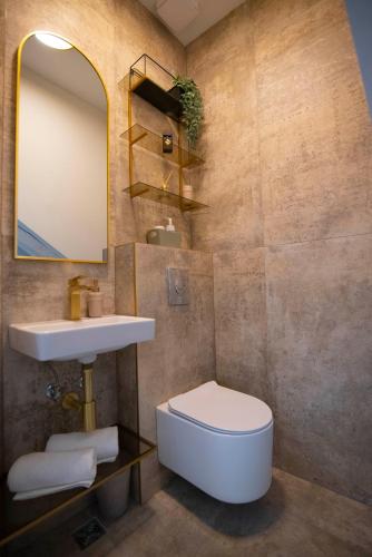 a bathroom with a sink and a toilet and a mirror at Apartments Allegra in Sinj