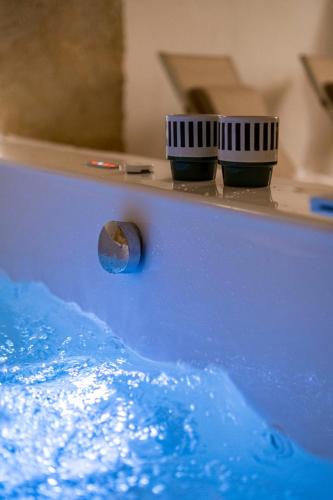 a tub filled with blue water with twocasters at Loft 900 - Home & SPA - A Timeless Luxury in Monopoli in Monopoli
