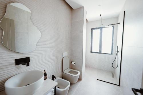 a white bathroom with a sink and a toilet at Villa Escape 21 in Durrës