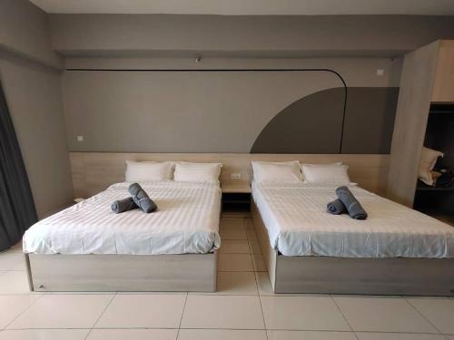 two beds in a hotel room with two bedsitures at We Stay Studio Room Aeropod Near Airport,KKCity,TgAru Beach-6Pax in Kota Kinabalu