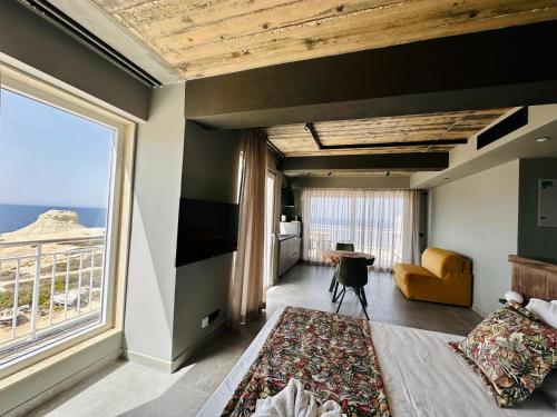 a bedroom with a bed and a large window at Salini Suites in Żebbuġ