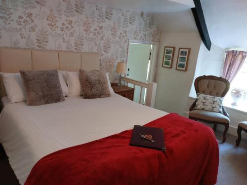 een slaapkamer met een bed met een boek erop bij Tudor Cottage in Bossington