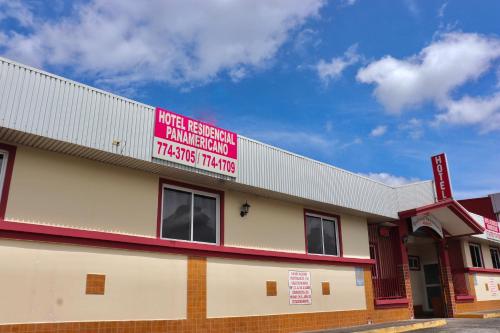 a building with a red sign on the side of it at Hotel Residencial Panamericano in David