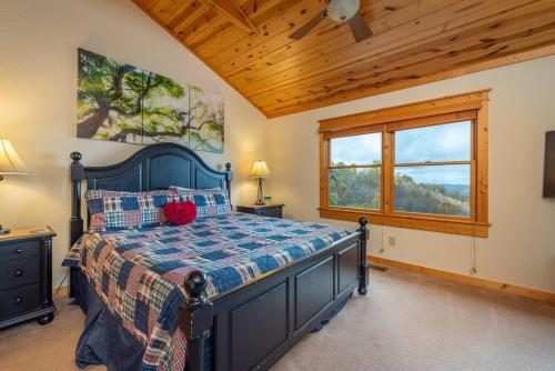 Swiss的住宿－Firefly Cabin! Hot Tub, Sauna, near Ski Resort，一间卧室设有一张床和木制天花板
