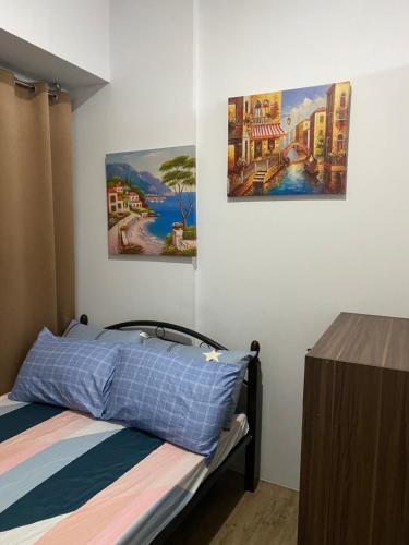 sypialnia z łóżkiem i dwoma obrazami na ścianie w obiekcie Anuva Suite ( Free Swimming Access) w mieście Manila