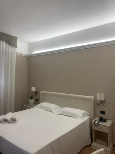 1 dormitorio con 1 cama blanca grande con sábanas blancas en Hotel Aquila en Castelfranco Emilia