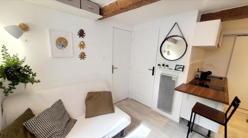 - un salon avec un canapé blanc et un miroir dans l'établissement Petit studio très calme proche du centre, à Marseille