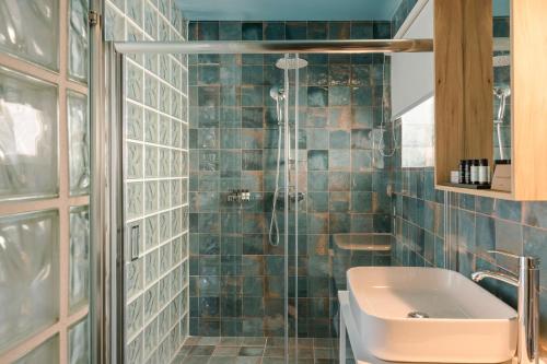 uma casa de banho com um lavatório e um chuveiro em The Blue em Skiathos