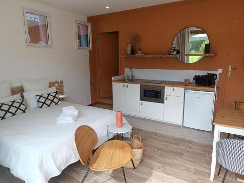 une chambre avec un grand lit et une cuisine dans l'établissement Le Jardin de Moulis, Saint Girons, Ariège, Pyrénées,, à Moulis