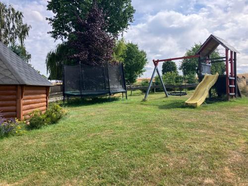 a park with a playground with a slide and a slideintend at Schäferwagen Kuschel vom Friesenhof Wieratal in Nobitz