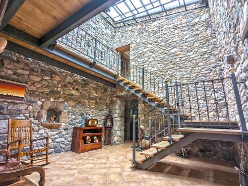 a stone building with a staircase and a stone wall at Can Carreres - Un lloc on desconnectar en família in El Pasteral