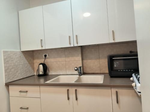 eine Küche mit einer Spüle und einer Mikrowelle in der Unterkunft דירה במרכז in Bene Beraq