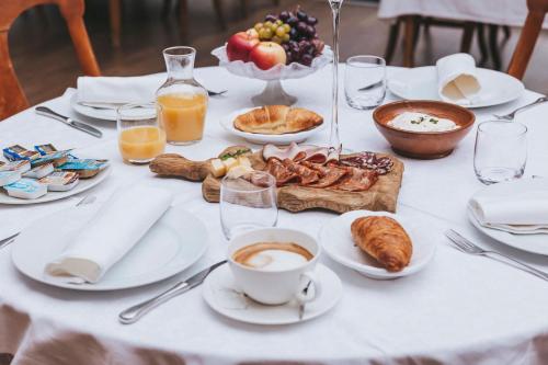Una mesa con alimentos para el desayuno y una taza de café. en Guesthouse Villa Zelenjak Ventek, en Kumrovec