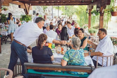 a waiter serving people at a table in a restaurant at Hotel Restoran Humsko in Trebinje