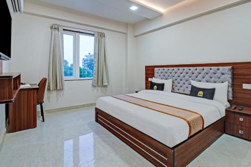 Un dormitorio con una cama y un escritorio y una ventana. en Super Townhouse OAK VS Shivanya, en Lucknow