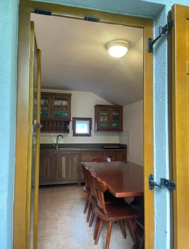 a dining room with a table and a kitchen at Juliana Cottage in Soča