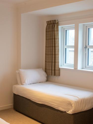 a bed in a room with a window at Loch Lomond Hotel in Balloch