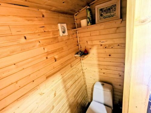La salle de bains est pourvue de toilettes et d'un mur en bois. dans l'établissement La Roulotte du Cagire - 4 pers - Pyrénées, à Villeneuve-de-Rivière