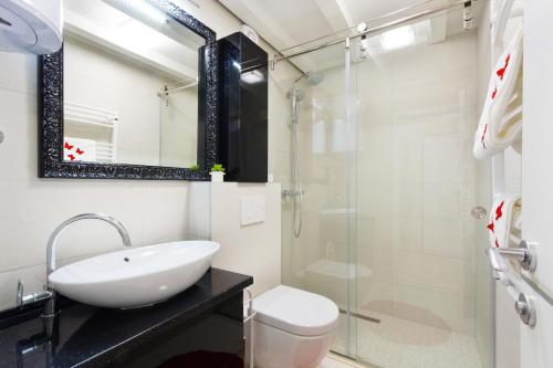 a bathroom with a sink and a toilet and a shower at Apartment Stone in Split