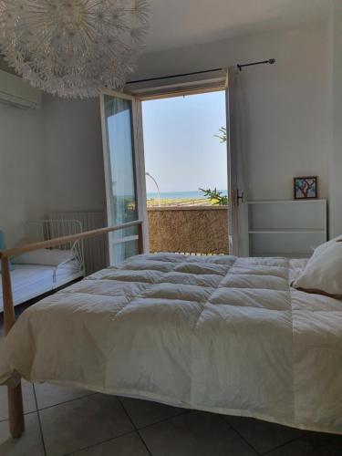 a bedroom with a bed with a view of the ocean at NEL BLU in Porto SantʼElpidio