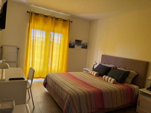 a bedroom with a bed and a yellow curtain at Casa do Horizonte in Bombarral