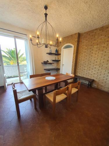 a dining room with a table and chairs and a chandelier at NEL BLU in Porto SantʼElpidio