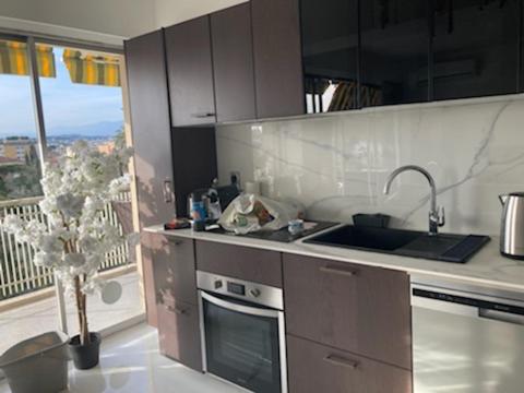 a kitchen with a sink and a stove top oven at Belle terrasse près du Martinez et des plages! in Cannes