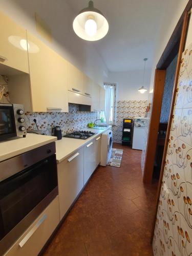 a kitchen with white cabinets and a stove top oven at NEL BLU in Porto SantʼElpidio