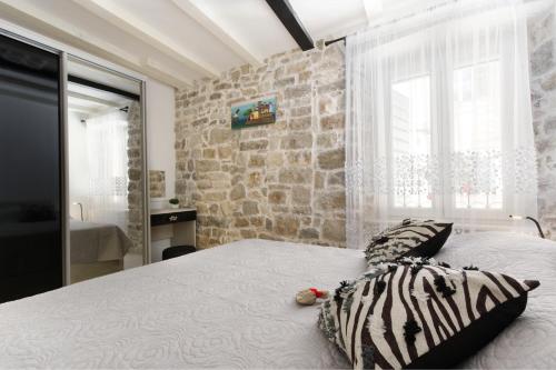 a bedroom with a bed with a stone wall at Apartment Stone in Split