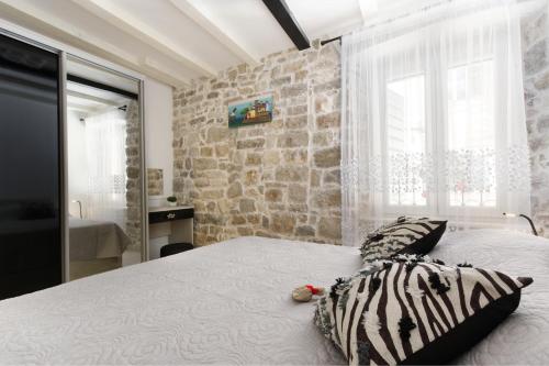 ein Schlafzimmer mit einem Bett vor einer Steinwand in der Unterkunft Apartment Stone in Split