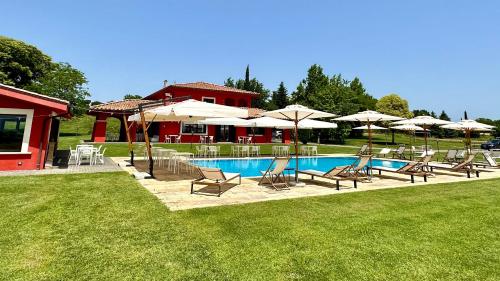 eine Gruppe von Stühlen und Sonnenschirmen neben einem Pool in der Unterkunft Agriturismo Borgo Imperiale in Valmontone