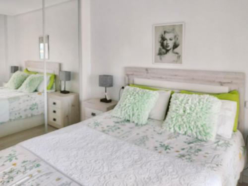 トレビエハにあるPurisima Sea View Apartmentのベッドルーム1室(緑と白の枕が備わるベッド1台付)