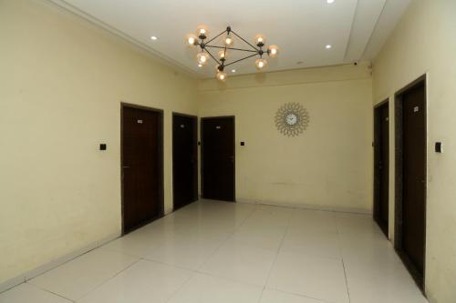 ein leeres Zimmer mit schwarzen Türen und einem Kronleuchter in der Unterkunft Stay10 Premium Service Apartments in Indore