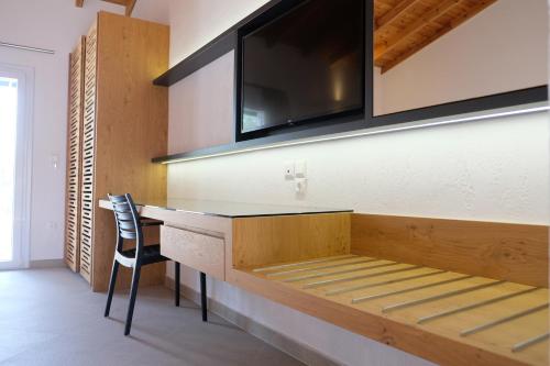 Zimmer mit einem Schreibtisch, einem TV und einem Stuhl in der Unterkunft Aeon Retreat in Rovies