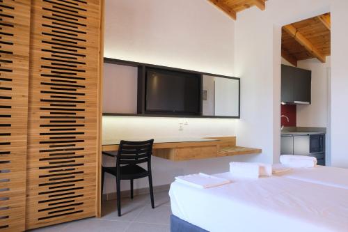 a bedroom with a bed and a desk with a television at Aeon Retreat in Rovies
