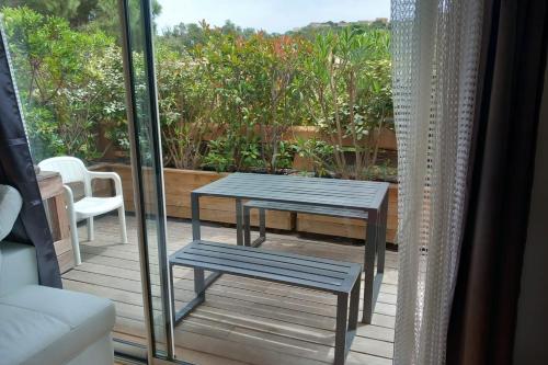 d'une terrasse avec une table et deux bancs sur un balcon. dans l'établissement Cosy cocoon with balcony close to the sea, à Porto-Vecchio