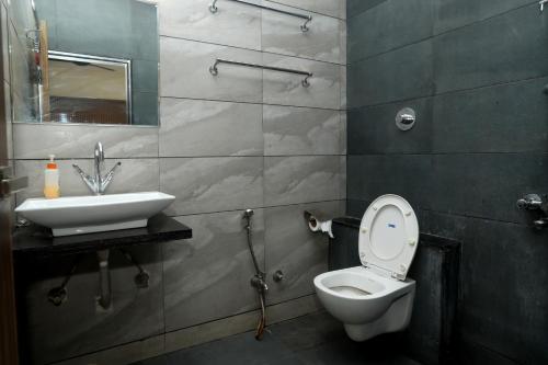 Stay10 Premium Service Apartments في إندوري: حمام مع مرحاض ومغسلة