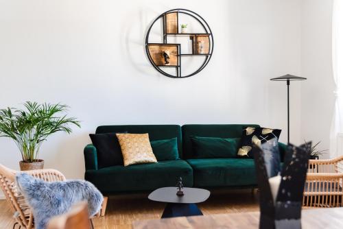 a living room with a green couch and a mirror at Hybrid Work-Play Retreat - 2BR, 1B central Kreuzberg in Berlin