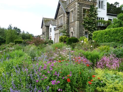 a garden in front of a house with flowers at Yewfield Vegetarian Guest house in Ambleside