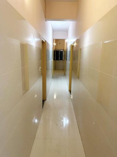 a hallway with a long corridor with white walls at Vbh Inn- Affordable and Budget Friendly in Jigani