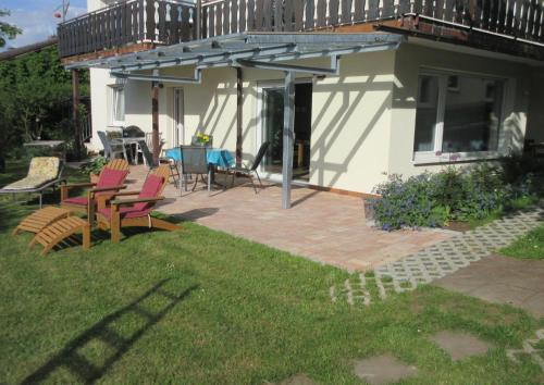 a patio with chairs and a deck with a table at Ferienwohnung Obstgarten in Bad König