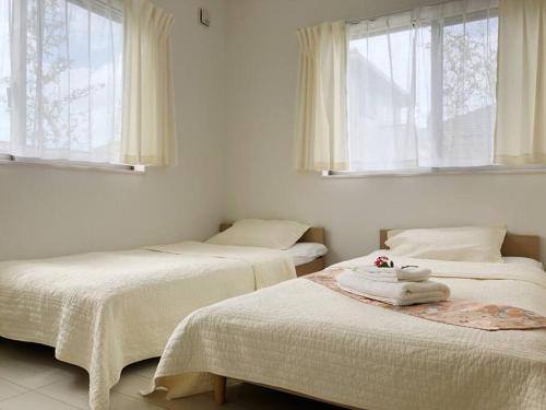 Cama ou camas em um quarto em 空港まで車で15分〜ビーチまで徒歩1分〜海沿いの野鶴居