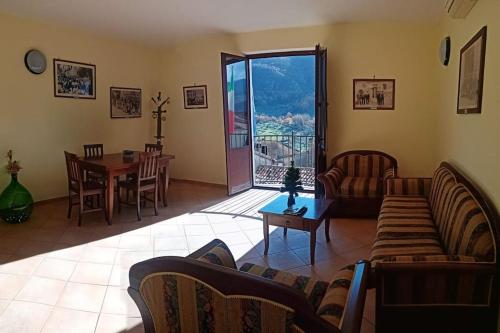 sala de estar con sofá y mesa con vistas en Intera casa con due stanze nel Parco del Cilento, en Piaggine