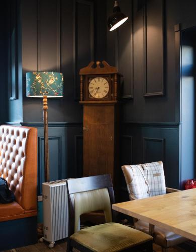a dining room with a grandfather clock and a table at Loch Lomond Hotel in Balloch