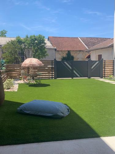a pillow laying on the grass in a backyard at L'HERMANCERIE in Priay