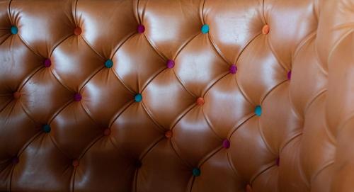 an image of a brown leather couch with pink and blue buttons at Loch Lomond Hotel in Balloch
