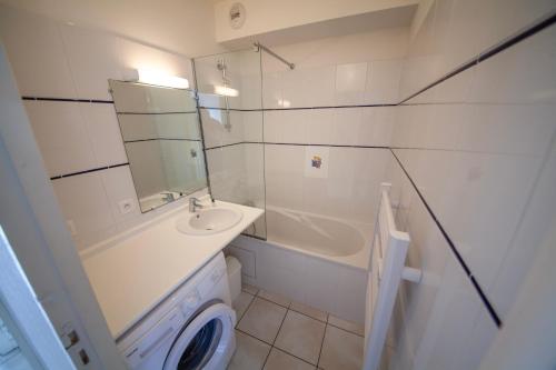W łazience znajduje się umywalka, toaleta i lustro. w obiekcie Résidence Belle Dune Blanche, maisons et appartements w mieście Biscarrosse-Plage