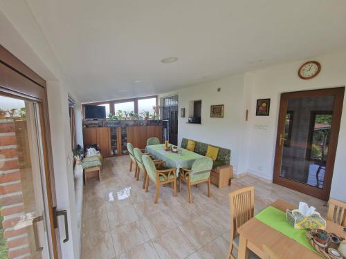 a dining room with a green table and chairs at Ubytovani Klára in Bulhary